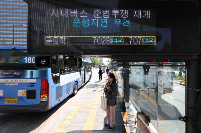 서울 시내버스 노조가 연휴가 끝난 뒤 첫차부터 준법투쟁(준법운행)을 재개한 7일 오전 서울 광화문의 한 버스정류장 전광판에 준법투쟁 재개로 인한 운행지연 안내문구가 표시되고 있다. [연합뉴스]